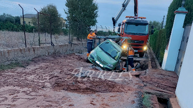 Un coche cae en un socavón tras reventar una canalización de agua